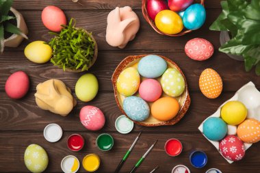 Mutfak masasında paskalya yumurtası resmi. Mutlu Paskalya kutlaması kavramı. Farklı şekillerde renkli paskalya yumurtaları. Resimler, tatiller için yumurta boyama süslemeleri.