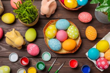 Mutfak masasında paskalya yumurtası resmi. Mutlu Paskalya kutlaması kavramı. Farklı şekillerde renkli paskalya yumurtaları. Resimler, tatiller için yumurta boyama süslemeleri.