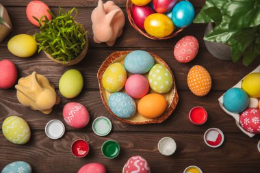 Mutfak masasında paskalya yumurtası resmi. Mutlu Paskalya kutlaması kavramı. Farklı şekillerde renkli paskalya yumurtaları. Resimler, tatiller için yumurta boyama süslemeleri.