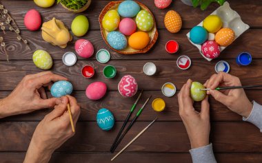 Aile, mutfak masasına Paskalya yumurtası boyamış. Mutlu Paskalya kutlaması kavramları. Farklı şekillerde renkli paskalya yumurtaları..