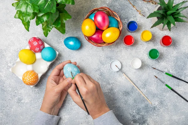 Kadınlar paskalya yumurtalarını mutfak ahşap masasında boyar. Mutlu Paskalya kutlaması kavramları. Farklı şekillerde renkli paskalya yumurtaları..