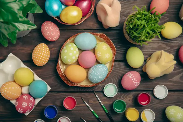 Mutfak masasında paskalya yumurtası resmi. Mutlu Paskalya kutlaması kavramı. Farklı şekillerde renkli paskalya yumurtaları. Resimler, tatiller için yumurta boyama süslemeleri.