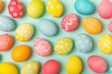 Parlak turkuaz arka planda Paskalya yumurtaları. Paskalya kutlaması. El yapımı renkli Paskalya yumurtaları. Mesaj için yer. Boşluğu kopyala.