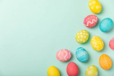 Parlak turkuaz arka planda Paskalya yumurtaları. Paskalya kutlaması. El yapımı renkli Paskalya yumurtaları. Mesaj için yer. Boşluğu kopyala.