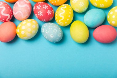 Parlak mavi arka planda Paskalya yumurtaları. Paskalya kutlaması. El yapımı renkli Paskalya yumurtaları. Mesaj için yer. Boşluğu kopyala.