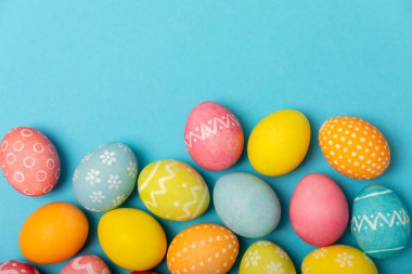 Parlak mavi arka planda Paskalya yumurtaları. Paskalya kutlaması. El yapımı renkli Paskalya yumurtaları. Mesaj için yer. Boşluğu kopyala.