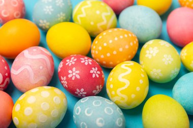 Parlak mavi arka planda Paskalya yumurtaları. Paskalya kutlaması. El yapımı renkli Paskalya yumurtaları. Mesaj için yer. Boşluğu kopyala.