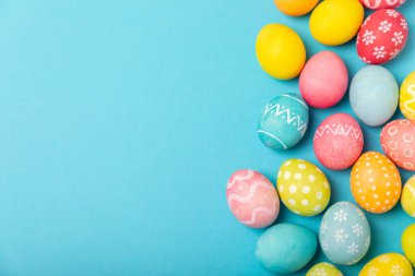 Parlak mavi arka planda Paskalya yumurtaları. Paskalya kutlaması. El yapımı renkli Paskalya yumurtaları. Mesaj için yer. Boşluğu kopyala.