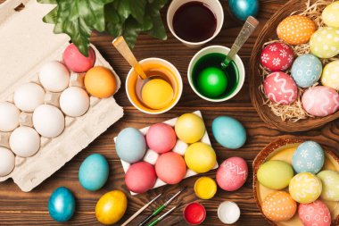 Mutfak masasında paskalya yumurtası resmi. Mutlu Paskalya kutlaması kavramı. Farklı şekillerde renkli paskalya yumurtaları. Resimler, tatiller için yumurta boyama süslemeleri.