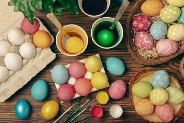 Mutfak masasında paskalya yumurtası resmi. Mutlu Paskalya kutlaması kavramı. Farklı şekillerde renkli paskalya yumurtaları. Resimler, tatiller için yumurta boyama süslemeleri.