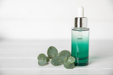 Okaliptüs, ahşap kaplamalı yeşil okaliptüs yapraklı cam bir şişede gerekli yağdır. Aromaterapi konsepti. Spa mı? Kozmetik ve vücut bakımı için doğal organik malzemeler.
