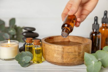 Okaliptüs, ahşap kaplamalı yeşil okaliptüs yapraklı cam bir şişede gerekli yağdır. Aromaterapi konsepti. Spa mı? Kozmetik ve vücut bakımı için doğal organik malzemeler.