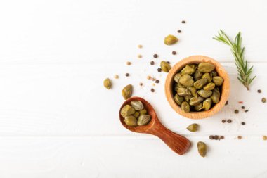 Ahşap mutfak masasında kapari. Deniz tuzu ve biberiyeli kapari. Turşu turşusu. Akdeniz mutfağı malzemesi. Organik baharatlar ve baharatlar. Boşluğu kopyala.