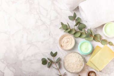 Tahta arka planda okaliptüs yapraklı güzel bir spa kompozisyonu. Vücut kremi, fırça, maske, temel yağ ve deniz tuzu içeren güzellik ve moda spa konsepti. Kozmetik ürün. Boşluğu kopyala.