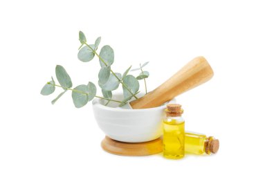 Okaliptüs yaprakları ve havan topu beyaz arka planda izole edildi. Spa konsepti. Alternatif tıp ve doğal kozmetik malzemeleri. Bir şişe gerekli yağ ve bir demet okaliptüs. Organik cilt bakımı