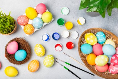 Mutfak masasında paskalya yumurtası resmi. Mutlu Paskalya kutlaması kavramı. Farklı şekillerde renkli paskalya yumurtaları. Resimler, tatiller için yumurta boyama süslemeleri.