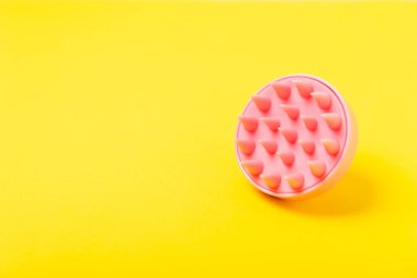 Sarı arka planda kafa masajı için fırça. Saç büyütmek için fırça, canlandırıcı fırça. Saç masajı. Uyarıcı fırça. Saç bakımı, kafa rahatlatma konsepti. Boşluğu kopyala.