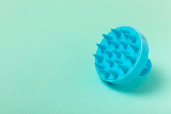 Кисть для массажа головы на мятном фоне. Кисть для стимулирования роста волос. Массаж волос. стимулирующая кисть. Уход за волосами, концепция расслабления головы. Копирование пространства.