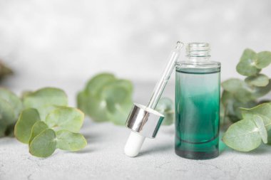 Okaliptüs, ahşap kaplamalı yeşil okaliptüs yapraklı cam bir şişede gerekli yağdır. Aromaterapi konsepti. Spa mı? Kozmetik ve vücut bakımı için doğal organik malzemeler.