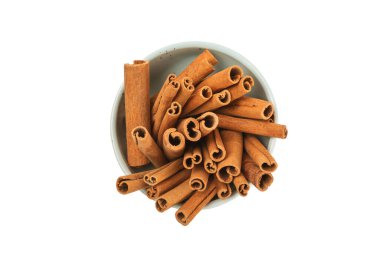Tarçınlı çubuklar beyaz arka planda izole edilmiş bir kasede. Tarçınlı rulo. Fırın, tatlı ve içecekler için baharatlı baharat. Güzel kokulu tarçın..