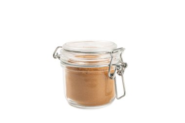 Beyaz arka planda izole edilmiş kavanozdaki tarçın tozu. Fırın ve içecekler için baharatlı baharat. Güzel kokulu tarçın..