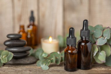 Okaliptüs, ahşap kaplamalı yeşil okaliptüs yapraklı cam bir şişede gerekli yağdır. Aromaterapi konsepti. Spa mı? Kozmetik ve vücut bakımı için doğal organik malzemeler.