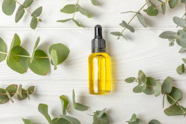 Okaliptüs, ahşap kaplamalı yeşil okaliptüs yapraklı cam bir şişede gerekli yağdır. Aromaterapi konsepti. Spa mı? Kozmetik ve vücut bakımı için doğal organik malzemeler.