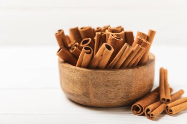 Tarçınlı çubuklar ahşap bir arka planda. Tarçınlı rulo. Fırın, tatlı ve içecekler için baharatlı baharat. Güzel kokulu tarçın. Tarçın tozu yakın plan. Mesaj için yer. Boşluğu kopyala