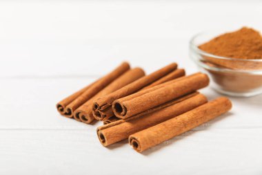 Tarçınlı çubuklar ahşap bir arka planda. Tarçınlı rulo. Fırın, tatlı ve içecekler için baharatlı baharat. Güzel kokulu tarçın. Tarçın tozu yakın plan. Mesaj için yer. Boşluğu kopyala