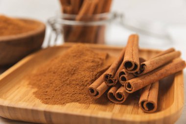 Tarçınlı çubuklar ahşap bir arka planda. Tarçınlı rulo. Fırın, tatlı ve içecekler için baharatlı baharat. Güzel kokulu tarçın. Tarçın tozu yakın plan. Mesaj için yer. Boşluğu kopyala