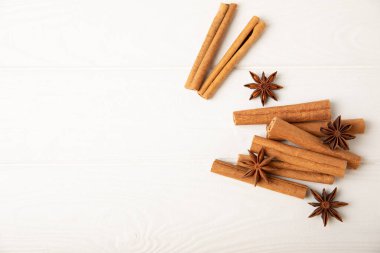 Tarçın çubukları ve anason desenli arka planda. Tarçınlı rulo ve yıldız anason. Fırın, tatlı ve içecekler için baharatlı baharat. Güzel kokulu tarçın. Mesaj için uygun bir yer. Boşluğu kopyala.