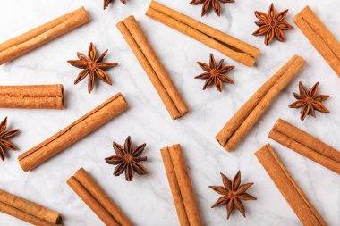 Tarçın çubukları ve anason desenli arka planda. Tarçınlı rulo ve yıldız anason. Fırın, tatlı ve içecekler için baharatlı baharat. Güzel kokulu tarçın. Mesaj için uygun bir yer. Boşluğu kopyala.