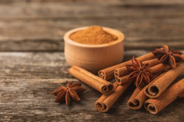 Tarçın çubukları ve anason desenli arka planda. Tarçınlı rulo ve yıldız anason. Fırın, tatlı ve içecekler için baharatlı baharat. Güzel kokulu tarçın. Mesaj için uygun bir yer. Boşluğu kopyala.