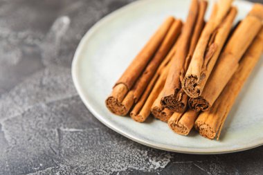 Seylan tarçın. Tarçın ahşap bir zemine yapışır. Tarçın rulosu ve pudra. Fırın, tatlı ve içecekler için baharatlı baharat. Güzel kokulu tarçın. Yakın plan. Mesaj için yer. Boşluğu kopyala