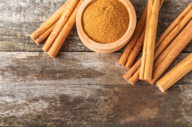 Seylan tarçın. Tarçın ahşap bir zemine yapışır. Tarçın rulosu ve pudra. Fırın, tatlı ve içecekler için baharatlı baharat. Güzel kokulu tarçın. Yakın plan. Mesaj için yer. Boşluğu kopyala