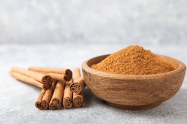 Ahşap kaplamalı bir kasede tarçın tozu. Fırın, tatlı ve içecekler için baharatlı baharat. Güzel kokulu tarçın. Tarçın çubuğu. Mesaj için yer. Boşluğu kopyala.