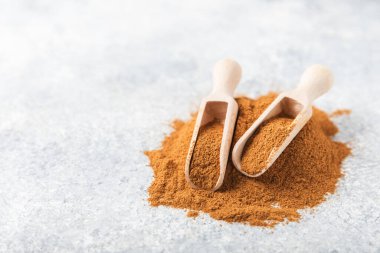 Ahşap kaplamalı bir kasede tarçın tozu. Fırın, tatlı ve içecekler için baharatlı baharat. Güzel kokulu tarçın. Tarçın çubuğu. Mesaj için yer. Boşluğu kopyala.