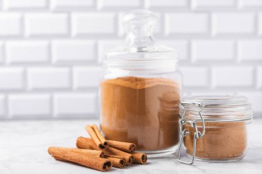 Ahşap kaplamalı bir kasede tarçın tozu. Fırın, tatlı ve içecekler için baharatlı baharat. Güzel kokulu tarçın. Tarçın çubuğu. Mesaj için yer. Boşluğu kopyala.