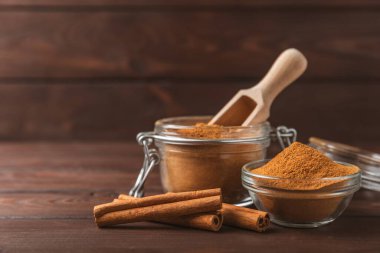 Ahşap kaplamalı bir kasede tarçın tozu. Fırın, tatlı ve içecekler için baharatlı baharat. Güzel kokulu tarçın. Tarçın çubuğu. Mesaj için yer. Boşluğu kopyala.