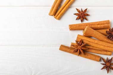 Seylan tarçın çubukları ve anason desenli ahşap bir arka planda. Tarçın rulosu ve yıldız anason. Fırın, tatlı ve içecekler için baharatlı baharat. Güzel kokulu tarçın. Mesaj için uygun bir yer. Boşluğu kopyala.