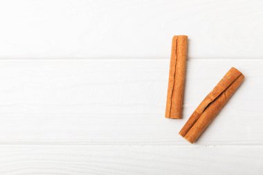 Tarçınlı çubuklar ahşap bir arka planda. Tarçınlı rulo. Fırın, tatlı ve içecekler için baharatlı baharat. Güzel kokulu tarçın. Tarçın tozu yakın plan. Mesaj için yer. Boşluğu kopyala