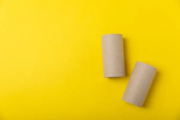Empty toilet paper roll. Empty toilet paper rolls for the toilet, on a bright yellow background. Paper tube of toilet paper. Place for text. Copy space. Flat lay. Eco-friendly reuse recycle