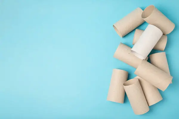Empty toilet paper roll. Rolls of toilet paper on a blue background. Paper tube of toilet paper. Place for text. Copy space. Flat lay. Eco-friendly reuse recycle