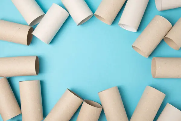 Empty toilet paper roll. Rolls of toilet paper on a blue background. Paper tube of toilet paper. Place for text. Copy space. Flat lay. Eco-friendly reuse recycle