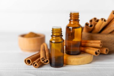 Tarçın aromatik gerekli yağ ve tarçın çubukları ahşap bir arka planda. Aromaterapi. Organik kozmetik yağı. Spa konsepti. Mesaj için yer. Boşluğu kopyala.