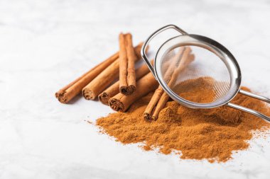 Ahşap kaplamalı bir kasede tarçın tozu. Fırın, tatlı ve içecekler için baharatlı baharat. Güzel kokulu tarçın. Tarçın çubuğu. Mesaj için yer. Boşluğu kopyala.