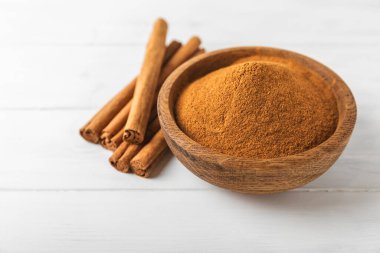 Ahşap kaplamalı bir kasede tarçın tozu. Fırın, tatlı ve içecekler için baharatlı baharat. Güzel kokulu tarçın. Tarçın çubuğu. Mesaj için yer. Boşluğu kopyala.