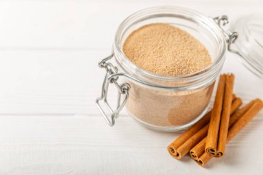 Tarçın şekeri arkaplanda. Arka planda bir kasede ev yapımı tarçın şekeri. Esmer şeker. İçecekler ve pişirme için baharat karışımı. Mesaj için yer. Boşluğu kopyala.