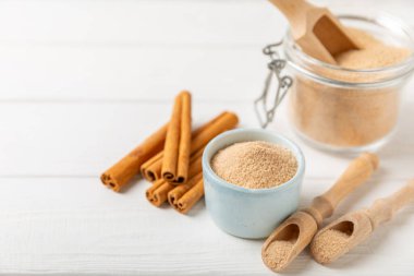 Tarçın şekeri arkaplanda. Arka planda bir kasede ev yapımı tarçın şekeri. Esmer şeker. İçecekler ve pişirme için baharat karışımı. Mesaj için yer. Boşluğu kopyala.