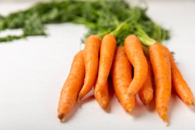 Ahşap kaplamalı havuç. Beyaz arka planda taze ve organik havuçlar. Havuç dilimleri. Vejetaryen. Salata için malzemeler. Mesaj için yer. Uzayı kopyala Düz